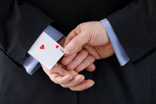 istock Close up man suit holds ace card behind his back 1220314832