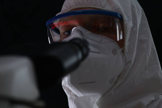 mâle dans la combinaison protectrice biochimiste surveillant le coronavirus chinois - gogles photos et images de collection
