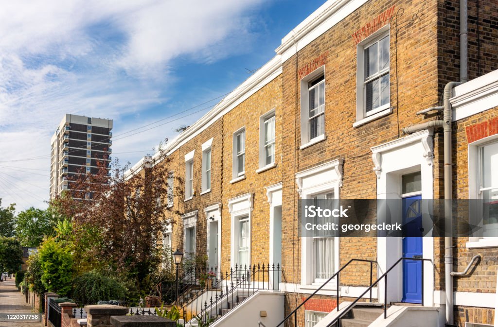 East London terraced houses and tower block A series of brick-built terraced houses, with a tower block in the distance. House Stock Photo