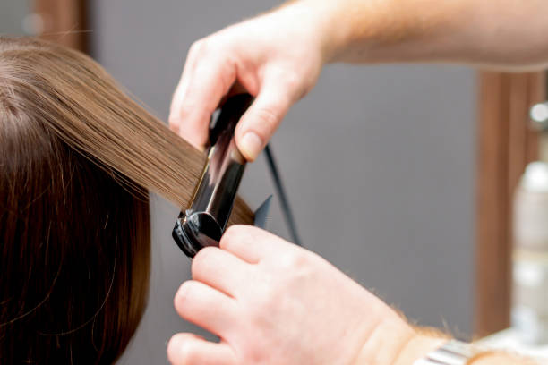 peluquería alisa el pelo de la mujer. - short working long human hand fotografías e imágenes de stock