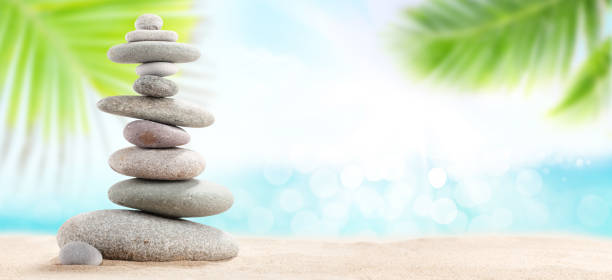 istock Pyramid of sea pebbles on a sunny sand beach 1220321400