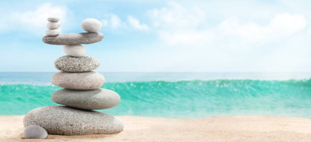 istock Pyramid of sea pebbles on a sunny sand beach 1220321429
