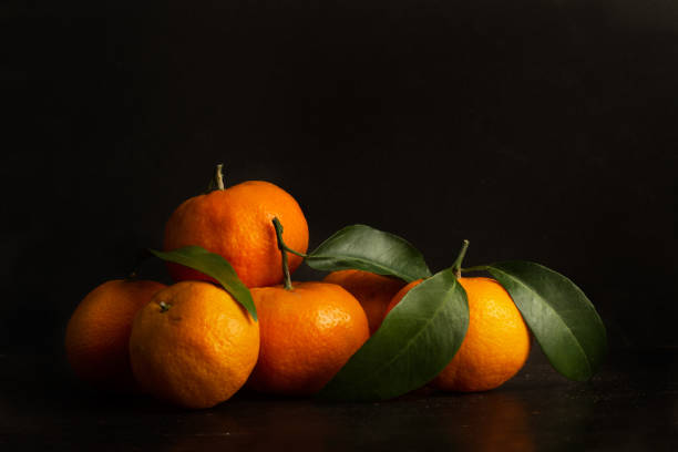istock Heap of oranges with green leaves 1220322075