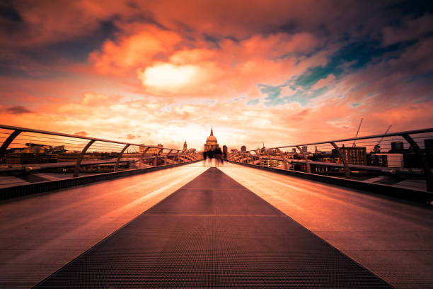 Nighttime view from the illuminated Millennium Bridge towards the majestic St. Paul’s Cathedral in London – stunning architecture with atmospheric lighting and urban ambiance