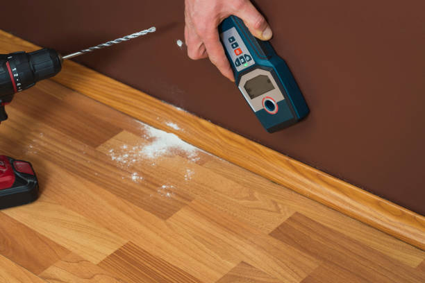 istock Man hand is scanning wall by cable detector to find a cable before drilling in. 1220325888