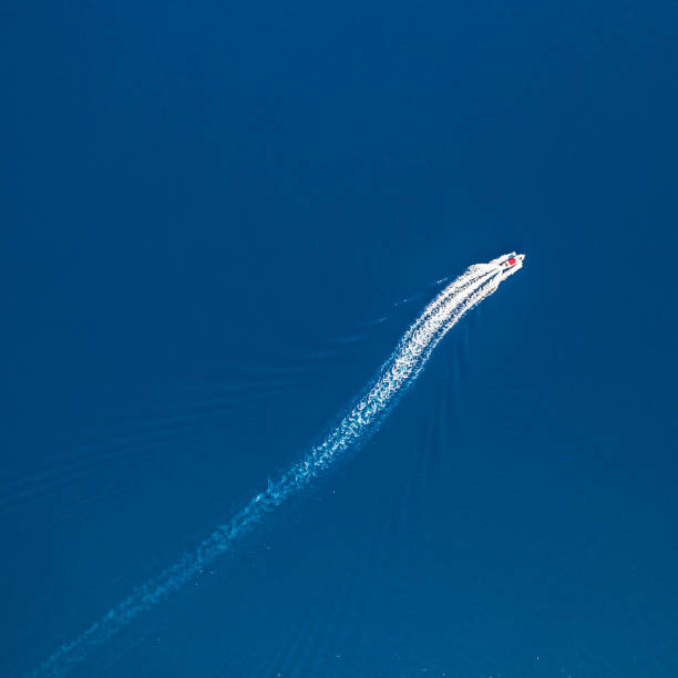istock Top down view on fast motorboat, which is leaving foam track on water surface. 1220326780