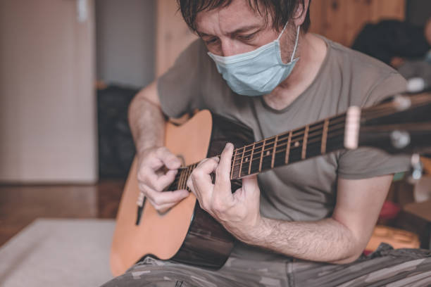 istock Man playing acoustic guitar in home quarantine self-isolation 1220328193