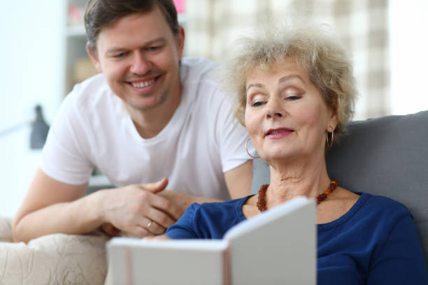 istock Elderly lady sits sofa watches album with her son 1220328954