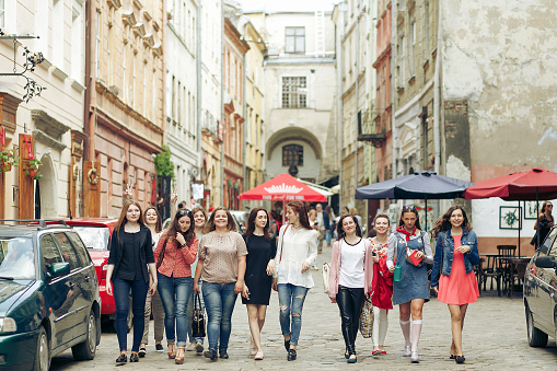 many confident young happy women walking having fun on background of old european city street, celebrating friendship concept, moments of happiness