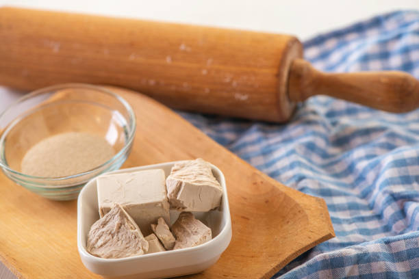 levure séchée et fraîche sur un bacground de cuisine blanche avec rouleau à pâtisserie en bois - bacground photos et images de collection