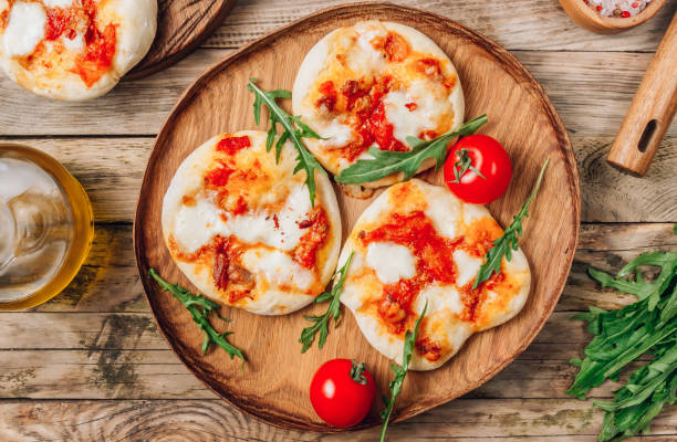 le pizzete. mini pizzas maison bolognaise. sauce tomate, fromage mozzarella et viande hachée. table en bois rustique. concept de séjour à la maison - healthy eating italian culture traditional culture close up photos et images de collection