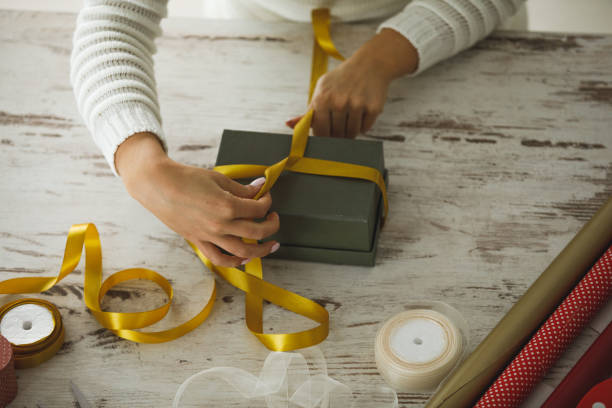 istock Placing gift upside down to decorate it with golden lace 1220331543