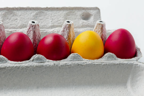 huevos de color rojo y uno amarillo - carton multi colored easter egg easter fotografías e imágenes de stock