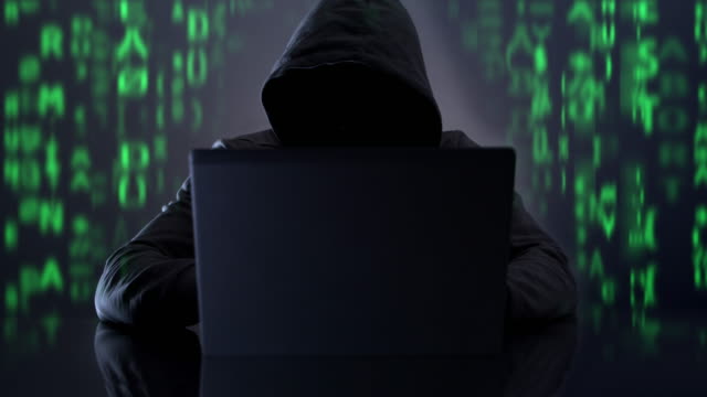 Hooded hacker. Cyber crime wth code.