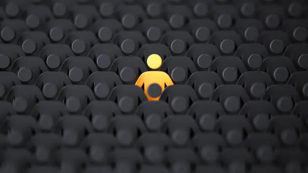 Photo of Yellow human shape among dark ones. Standing out of crowd concept