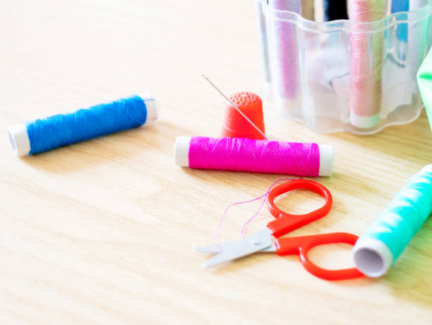 istock Spools of thread, bobbin, scissors and sewing accessories on a wooden background with shallow deep of field 1220333078