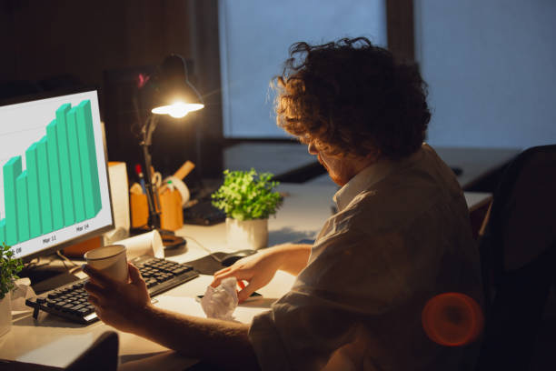 istock Man working in office alone during coronavirus or COVID-19 quarantine, staying to late night 1220334270