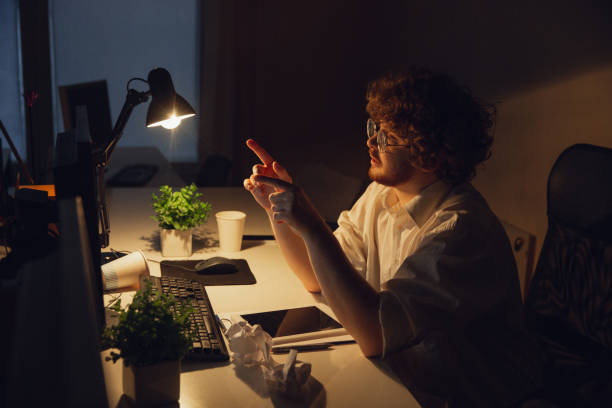 istock Man working in office alone during coronavirus or COVID-19 quarantine, staying to late night 1220334316