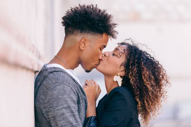 fidanzata amorevole mostrando affetto in pubblico - couple black american culture kissing foto e immagini stock