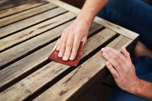 man sitting outdoors on terrace and sanding wooden furniture - grinding imagens e fotografias de stock