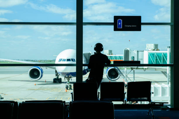 istock isolated man charging his phone at the airport before his flight 1220337462