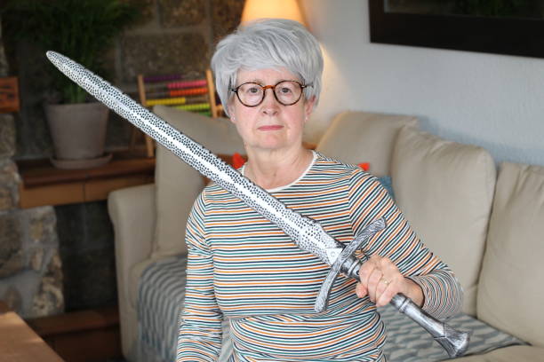 Senior woman holding a sword Senior woman holding a sword. cosplay photos stock pictures, royalty-free photos & images