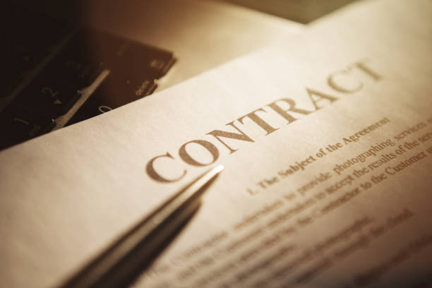 istock Close-up of silver pen on contract with sunlight. Selective focus. 1220340056