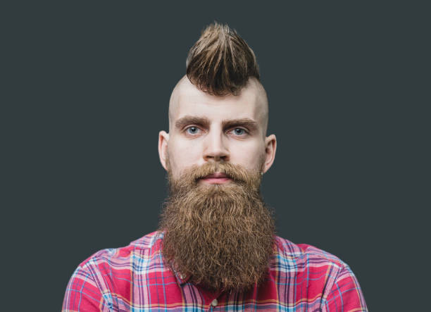 Young punk man close up portrait Punk styled men with Mohawk hairstyle is smiling. Isolated on gray background mohawk stock pictures, royalty-free photos & images