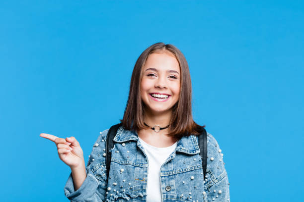 istock Happy teenge girl pointing with finger at copy space 1220343130