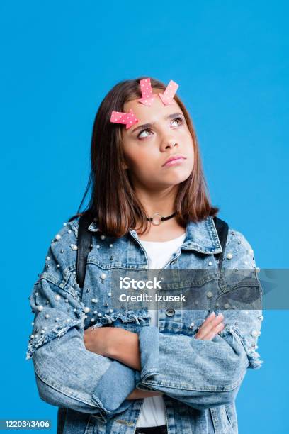 Pensive Female Hight School Student With Adhesive Note On Forehead Stock Photo - Download Image Now