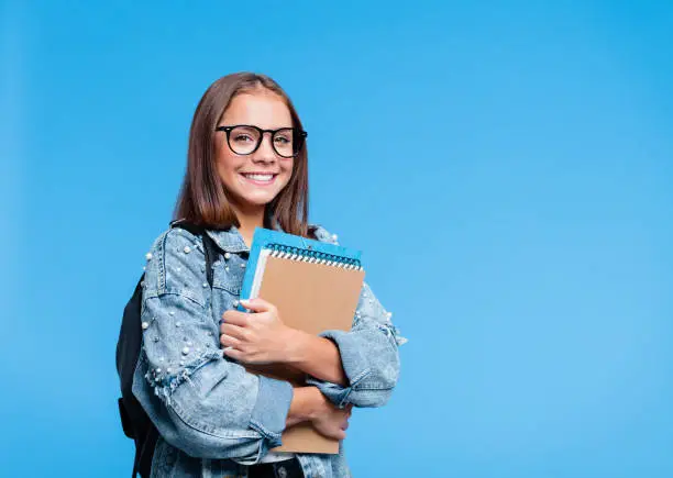 Photo of Portrait of female high school student holding books