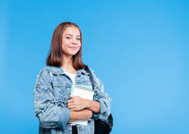istock Portrait of female high school student holding notebooks 1220344604