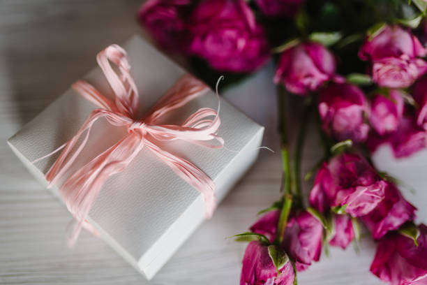 Gift box and pink roses on wooden background. Postcard. Space for text message. Flowers concept. Holiday greeting card for Valentines, Women's, Mother's Day, Easter. Happy Birthday. Wedding invitation caja de regalo y rosas rosas sobre fondo de madera. tarjeta postal. espacio para el mensaje de texto. concepto de flores. tarjeta de felicitación navideña para san valentín, día de la mujer, día de la madre, pascua. feliz cumpleaños. invitación de b