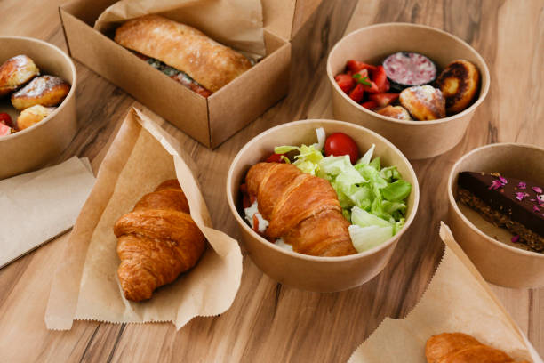 monte de alimentos pedidos em recipientes de papel em mesa texturizada de madeira. - box cake food lunch - fotografias e filmes do acervo