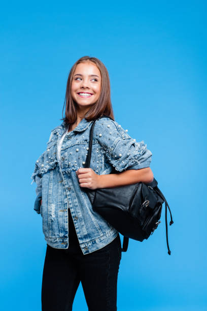 istock Pretty female high school student against blue background 1220347002