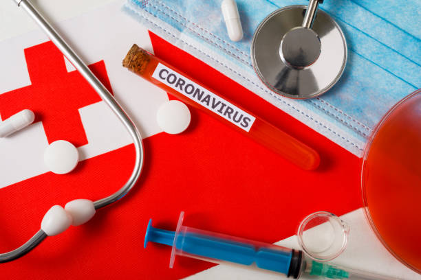 istock Coronavirus, nCoV concept. Top view protective breathing mask, stethoscope, syringe, pills on the flag of Tonga. 1220347155