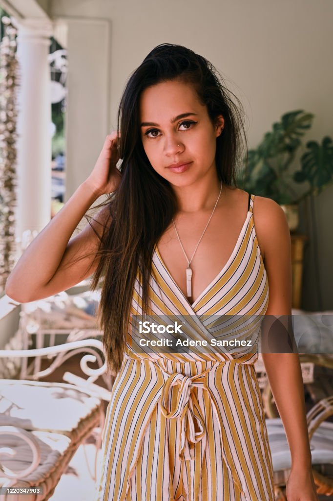 Covergirl good looks Shot of a beautiful young woman standing on the french porch of her home 20-29 Years Stock Photo