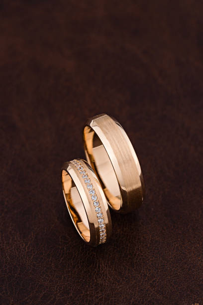 istock Rose gold wedding rings with diamonds and matte surface on brown leather background. 1220348216