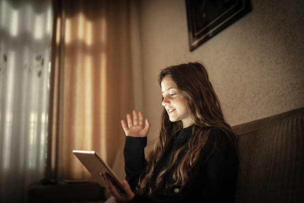 Girl doing a video call via digital tablet at home