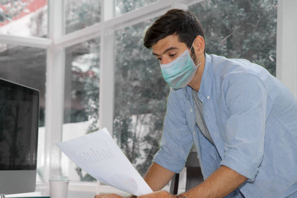 istock Caucasian man works at home with face mask 1220352486
