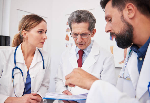 istock Three doctors discussing medical records in doctor’s office 1220352832