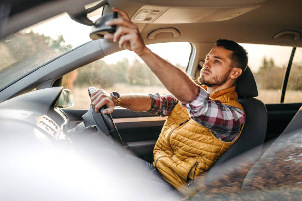 istock Man adjusting a rearview mirror in the car 1220354099