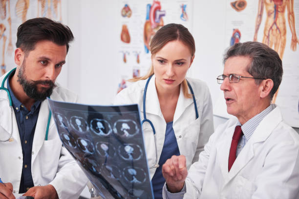 istock Three busy doctors discussing some medical records 1220354550