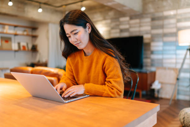 istock Young stylish woman using laptop at home 1220356119