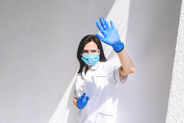太陽の光から隠れて防護服を着た女の子の医者。 - chemical agent ストックフォトと画像