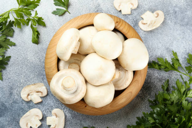 istock Uncooked mushrooms washed clean. Top view of raw champignons. 1220359957
