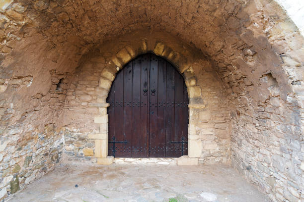 A closed wooden door to a stone building. The old wooden door to the Church.