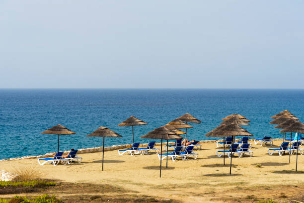 istock Beach sunbeds and parasols overlooking turquoise water 1220360163