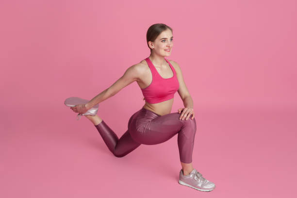 istock Beautiful young female athlete practicing on pink studio background, monochrome portrait 1220360173