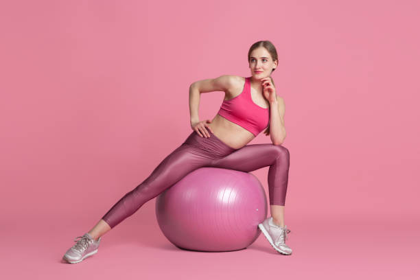istock Beautiful young female athlete practicing on pink studio background, monochrome portrait 1220360255